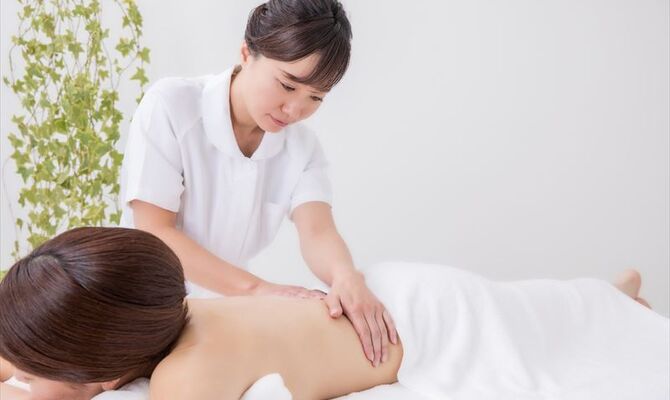 背中を揉むスタッフ