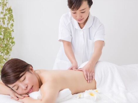 背中を施術する女性スタッフ